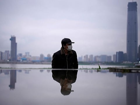 A man wearing a face mask walks at a park in Wuhan, Hubei province, the epicenter of China's coronavirus disease (COVID-19) outbreak, March 29, 2020.
