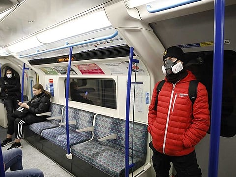 A passenger wears a ventilator mask on a London Underground tube train in London on March 30, 2020, as life in Britain continues during the nationwide lockdown to combat the novel coronavirus pandemic.