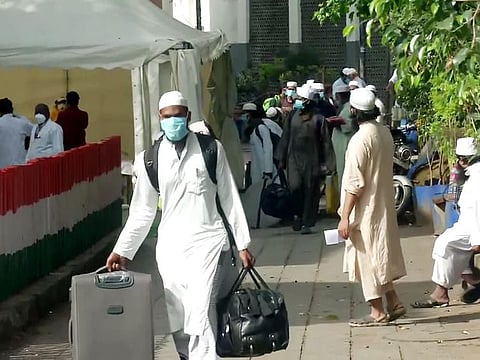 People from Markaz building wear a protective mask as they walk to board a bus that will be taken to the hospital amid concerns about the spread of coronavirus disease at Nizamuddin Area in New Delhi on Tuesday.