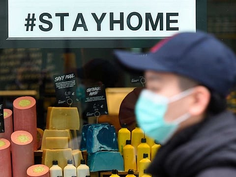 A pedestrian wearing a face mask walks past a shop window with the #stayhome slogan as the spread of the coronavirus disease (COVID-19) continues in Dresden, Germany, on March 31, 2020.