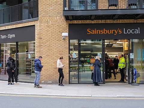 People follow social distancing rules as they are seen queueing outside a Sainsbury's store in Royal Wharf as the spread of the coronavirus disease (COVID-19) continues, in London