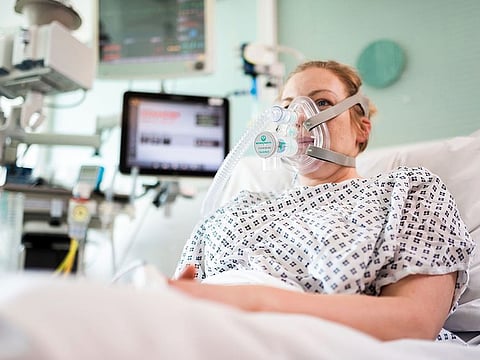 An undated handout image released by University College London in London, shows a volunteer patient posing whilst wearing the Continuous Positive Airway Pressure breathing aid.