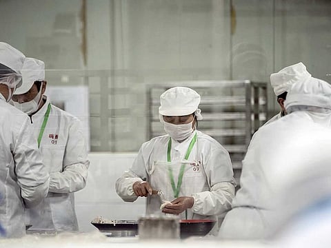 Employees wearing protective masks work on the dumpling production line at a Hi-Su Food Co. factory during a media tour in Shanghai, China, on Wednesday, April 1, 2020. Chinese manufacturing activity rebounded strongly in March, signaling that the world's second-largest economy is restarting just as it faces a growing threat from slumping external demand.