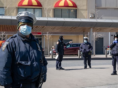 New York Police Department (NYPD) officers wear protective masks at the Fordham bus hub in the Bronx borough of New York, U.S., on Thursday, April 2, 2020.