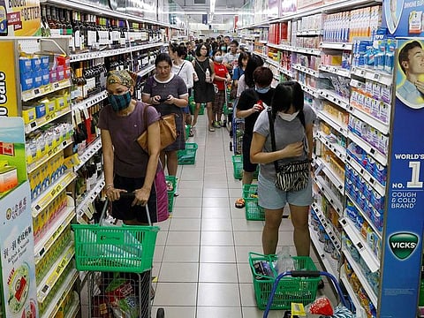 People stand behind markers as they practice social distancing while queueing up to buy food at a supermarket, during the outbreak of coronavirus disease (COVID-19), in Singapore April 3, 2020.