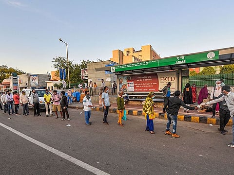 Homeless people stand in queue for food, being distributed by people during a nationwide lockdown in the wake of coronavirus pandemic, in New Delhi, Saturday, April 4, 2020.