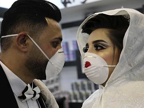 Palestinian newlyweds Baraa and Ammar pose for a picture in the West Bank village of Dora near Hebron on April 4, 2020, as authorities imposed restrictions on large gatherings in a bid to stem the spread of the COVID-19 coronavirus.