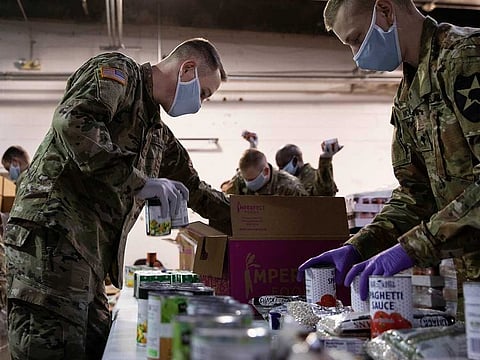 Members of the Army and Air National Guard pack food boxes at the Nourish Pierce County food bank in Tacoma, Washington, US, on April 3, 2020.