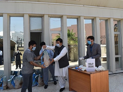 Pakistan Consul General Ahmed Amjad Ali handing over food bag to a needy person in Dubai.