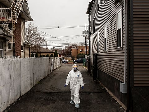 A medical worke walks toward tent setup outside Roseville Medical Group, to screen for the coronavirus, in East Orange, N.J., Friday, April 3, 2020.