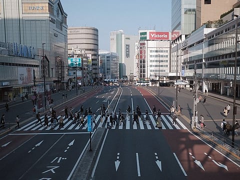 Pedestrian cross a road in the Shinjuku district of Tokyo, Japan, on Saturday, April 4, 2020. With Prime Minister Shinzo Abe’s government stuck on the brink of declaring a state of emergency that might lead to a lockdown, Japan’s restaurant, bar and chain stores are taking matters into their own hands by voluntarily shuttering hundreds of stores to help curb the spread of the coronavirus.