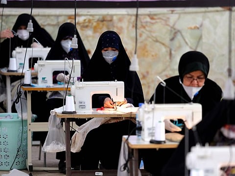 Iranian women, members of paramilitary organisation Basij, make face masks and other protective items at a mosque in the capital Tehran.