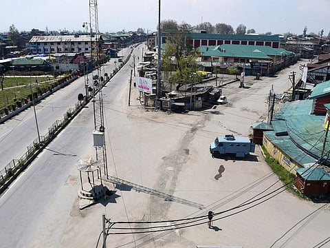 Policeman stand guard on a deserted street during the lockdown as a preventive measure against the COVID-19 coronavirus, in Srinagar, Kashmir