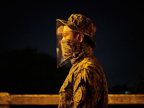 A police officer secures a checkpoint on in Manila, Philippines, Monday, April 6, 2020, during the coronavirus pandemic.