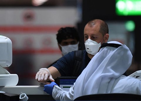 Passengers have their travel documents checked at Dubai International Airport