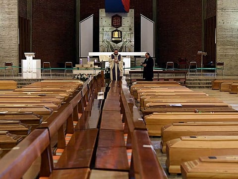 A local priest blesses coffins that have been piling up in a church due to a high number of deaths, before they are taken away by military trucks, as Italy struggles to contain the spread of coronavirus disease (COVID-19), in Seriate, Italy March 28, 2020.