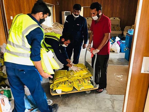 Pakistan Consulate General staff and volunteers prepare ration bags for distribution among the needy people in Dubai.