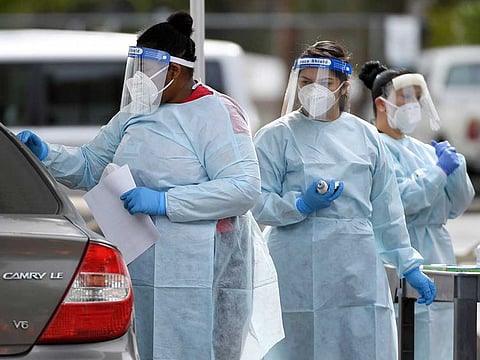 Certified medical assistants Lakietha Flourney, Yatziri Perez and Evelyn Laolagi conduct tests for COVID-19 at a drive-up testing station in the parking lot of UNLV Medicine on April 6, 2020 in Las Vegas, Nevada.