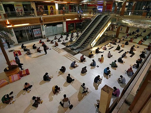 Migrant workers eat their dinner inside a shopping mall turned into a shelter during a 21-day nationwide lockdown to slow the spreading of coronavirus disease (COVID-19), in Ahmedabad, India, April 7, 2020.