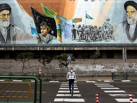 A man crosses an empty street under portraits of the late Iranian revolutionary founder Ayatollah Khomeini, right, and Supreme Leader Ayatollah Ali Khamenei, left, in Tehran, Iran. Due to the virus and the COVID-19 illness it causes, life has changed dramatically on Tehran's main highways, in the narrow corridors of its historical Grand Bazaar and in the public spaces under portraits of its leaders.