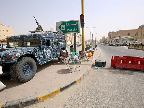 Kuwaiti police officers man a checkpoint at the entrance to the town of Jeleeb Al-Shuyoukh.