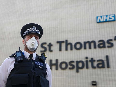 A police officer, wearing a protective face mask, stands outside St Thomas Hospital, operated by Guy's and St Thomas' NHS Foundation Trust, where UK Prime Minister Boris Johnson is being cared for in intensive care after struggling to shake off COVID-19, in London, UK, on Thursday, April 9, 2020.