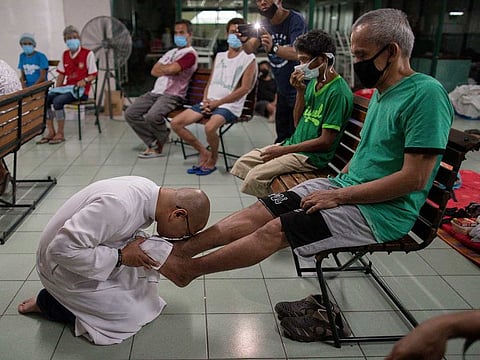 A Catholic priest kisses the feet of a homeless man during a traditional Holy Thursday ceremony at a university that temporirily shelters the homeless amid the lockdown to contain the coronavirus disease (COVID-19), in Manila, Philippines, April 9, 2020.