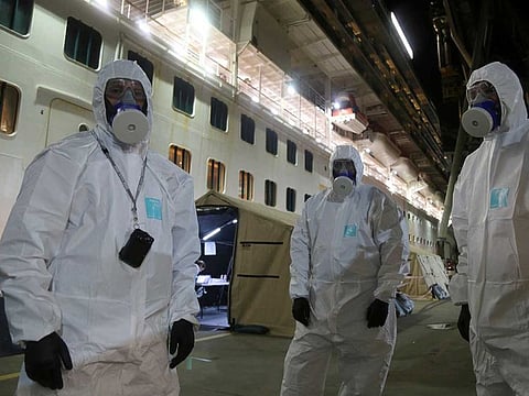 Investigators in protective gear prepare to board the Ruby Princess cruise ship at Wollongong, Australia on April 8, 2020. Police boarded the cruise ship to seize evidence and question crew members after the vessel was linked to hundreds of COVID-19 cases and more than a dozen deaths across Australia.