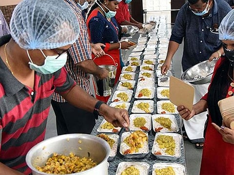 Volunteers preparing food packets in a community kitchen to distribute among the needy during the nationwide lockdown in Kochi.