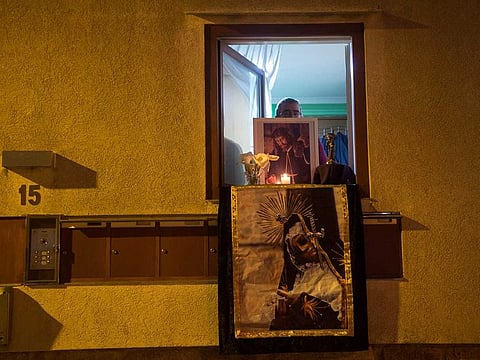 A man holds an image of Jesus Christ from his window, to celebrate Easter in Cambados after religious processions were cancelled during a national lockdown to prevent the spread of the COVID-16 disease.