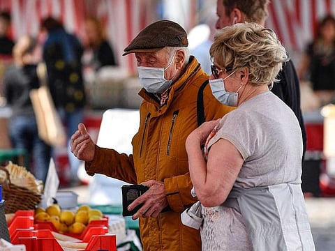 Elderly people go shopping at a market in Aachen, Germany, on April 9, 2020.  The new coronavirus causes mild or moderate symptoms for most people, but for some, especially older adults and people with existing health problems, it can cause more severe illness or death.