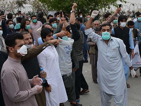 Doctors and paramedics shout slogans during a protest against the unavailability of safety equipment to handle coronavirus cases  in Pakistan's southwestern city of Quetta on April 6, 2020.