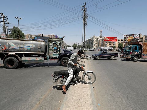 A boy brings his motorbike across a sidewalk, as the road is blocked by trucks, during a lockdown after the provincial government sealed eleven densely populated neighbourhoods amid the outbreak of the coronavirus disease in Karach on April 12.