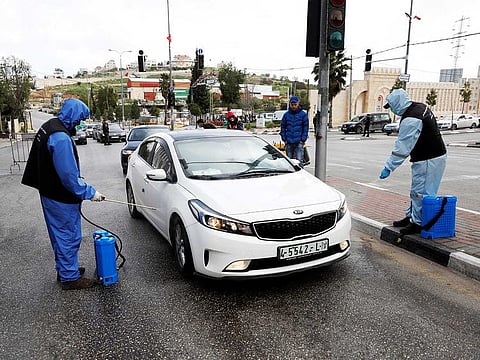 Palestinian workers sanitise cars during a home-confinement order to prevent the spread of the coronavirus disease (COVID-19), in Hebron in the Israeli-occupied West Bank, on April 7, 2020.