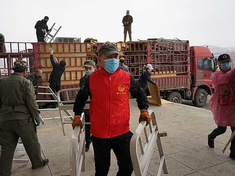 Workers and volunteers wearing face masks move bed parts into a makeshift hospital which has been converted from an office building to treat patients with the novel coronavirus disease (COVID-19) in Suifenhe, a city of Heilongjiang province on the border with Russia, China April 10, 2020.