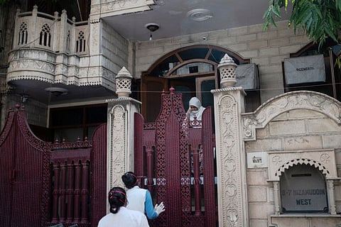 Health care workers speak with a resident in Nizamuddin West, where a gathering at the Tablighi Jamaat mosque and seminary became the centre of a coronavirus outbreak, in New Delhi, April 8.