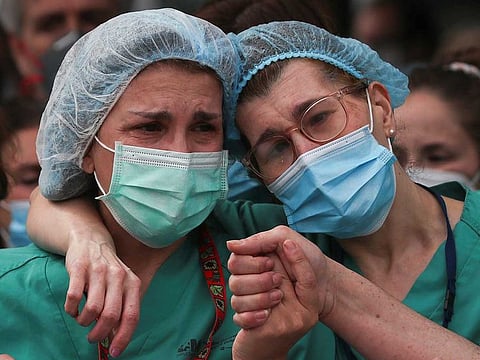 Health workers wearing protective face masks react during a tribute for their co-worker Esteban, a male nurse who died of the coronavirus disease, amid the coronavirus disease (COVID-19) outbreak, outside the Severo Ochoa Hospital in Leganes, Spain, April 13, 2020.
