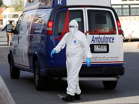 A first responder wearing a protective suit arrives to take a COVID-19 patient in UAE.
