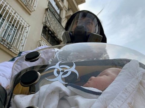 Cao Junjie poses for a picture with his two-month old baby inside a safety pod he created to protect his baby from the coronavirus disease at a residential compound in Shanghai, China.