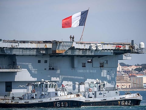 French navy soldiers wearing facemasks stand onboard the French aircraft carrier Charles de Gaulle, as it arrives in the southern French port of Toulon, with sailors onboard infected with COVID-19 (novel coronavirus).