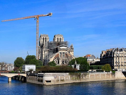 A crane stands by Notre Dame Cathedral Wednesday, April 15, 2020 in Paris. The Cathedral of Notre Dame stands crippled and alone, locked in a dangerous web of twisted scaffolding one year after a cataclysmic fire gutted its interior, toppled its famous spire and horrified the world.