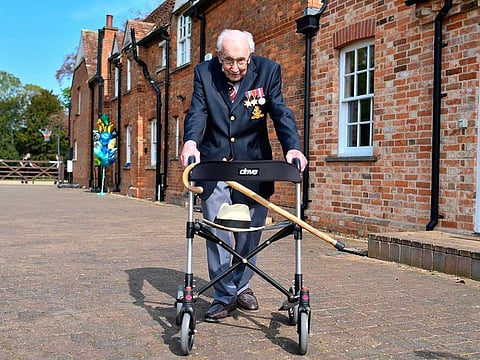 British World War II veteran Captain Tom Moore, 99, poses with his walking frame doing a lap of his garden in the village of Marston Moretaine, 80km north of London, on April 16, 2020.  A 99-year-old British World War II veteran Captain Tom Moore on April 16 completed 100 laps of his garden in a fundraising challenge for healthcare staff that has "captured the heart of the nation", raising more than £33million.