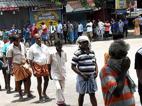 People stand in a queue as they wait for their turn to get the food packet which is being distributed by volunteers during the lockdown in Kochi on Tuesday.