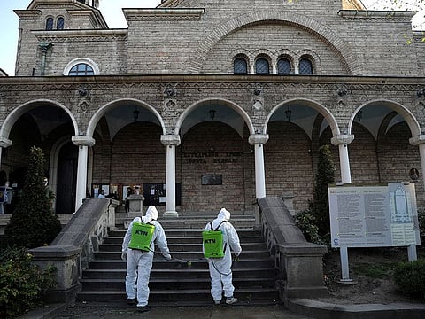 Workers spray disinfectant against the coronavirus outbreak outside St Nedelya church ahead of Orthodox Palm Sunday services in Sofia, Bulgaria, April 11, 2020.