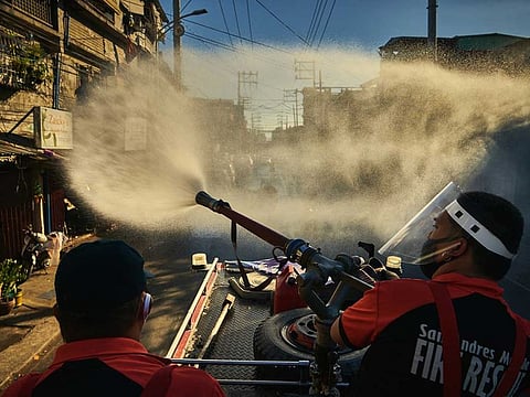Firefighters spray disinfectant along a road in Manila, Philippines, Monday, April 6, 2020, in an effort to keep the coronavirus from spreading. Philippines President Rodrigo Duterte's lockdown of Luzon, the Philippines' largest island and home to Manila, is moving into its second month, plunging the people of San Roque, a suburb of Quezon City, even deeper into poverty as the virus continues to rage.
