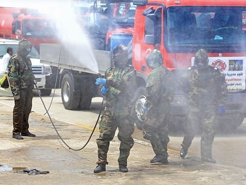 Iraqi civil defence workers sanitise the Tweirij district between Hilla and the southern Iraqi shrine city of Karbala against the spread of the coronavirus pandemic, on April 16, 2020
