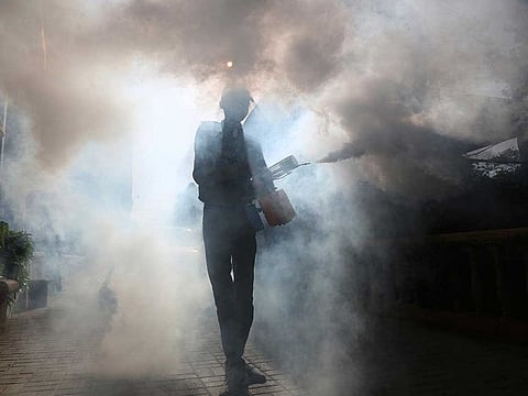 A volunteer disinfects the Karachi Press Club building in an effort to contain the outbreak of the coronavirus, in Pakistan on April 13, 2020.