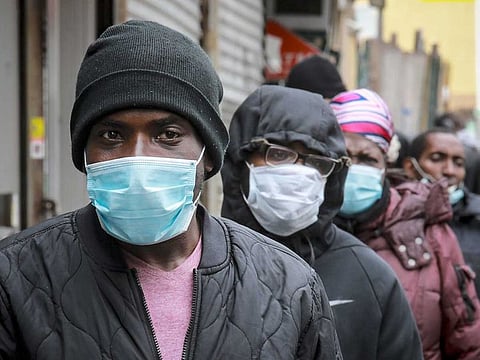 People wait for a distribution of masks and food from the Rev. Al Sharpton in the Harlem neighborhood of New York, after a new state mandate was issued requiring residents to wear face coverings in public due to COVID-19, on April 18, 2020.
