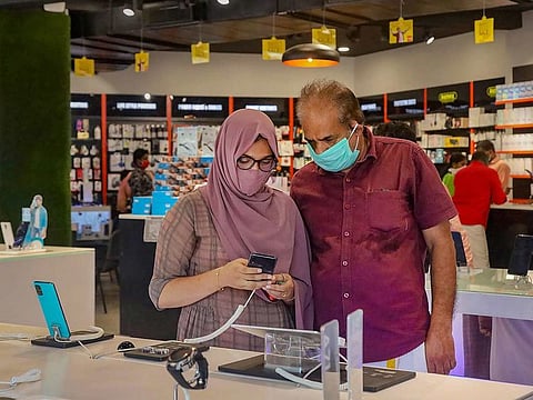 Customers purchase mobiles phones at a shop on the opening day of a once in a week market, during ongoing COVID-19 lockdown in Kozhikode, Sunday, April 19, 2020.