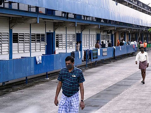 Migrant workers wearing protective face masks walk outside their living quarters in Singapore, April 8, 2020, during the coronavirus pandemic.